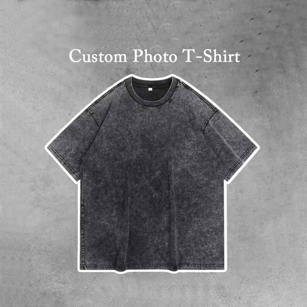 A photo of a plain solid black t-shirt with the words "Custom Photo T-Shirt" printed on the top. The t-shirt is available in personality.