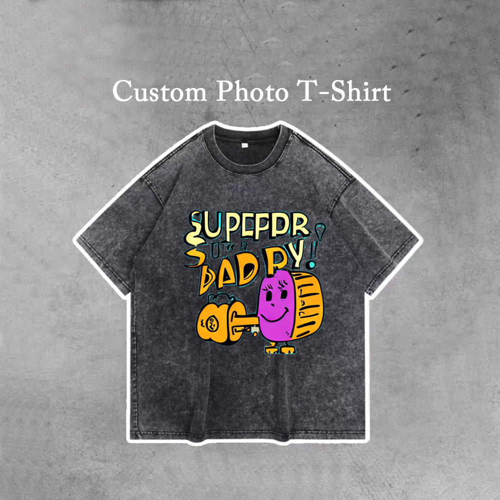 A solid black personalized t shirt with a doodle of Supper Daddy on it, there are words "Custom Photo T-Shirt" on the top of the picture.