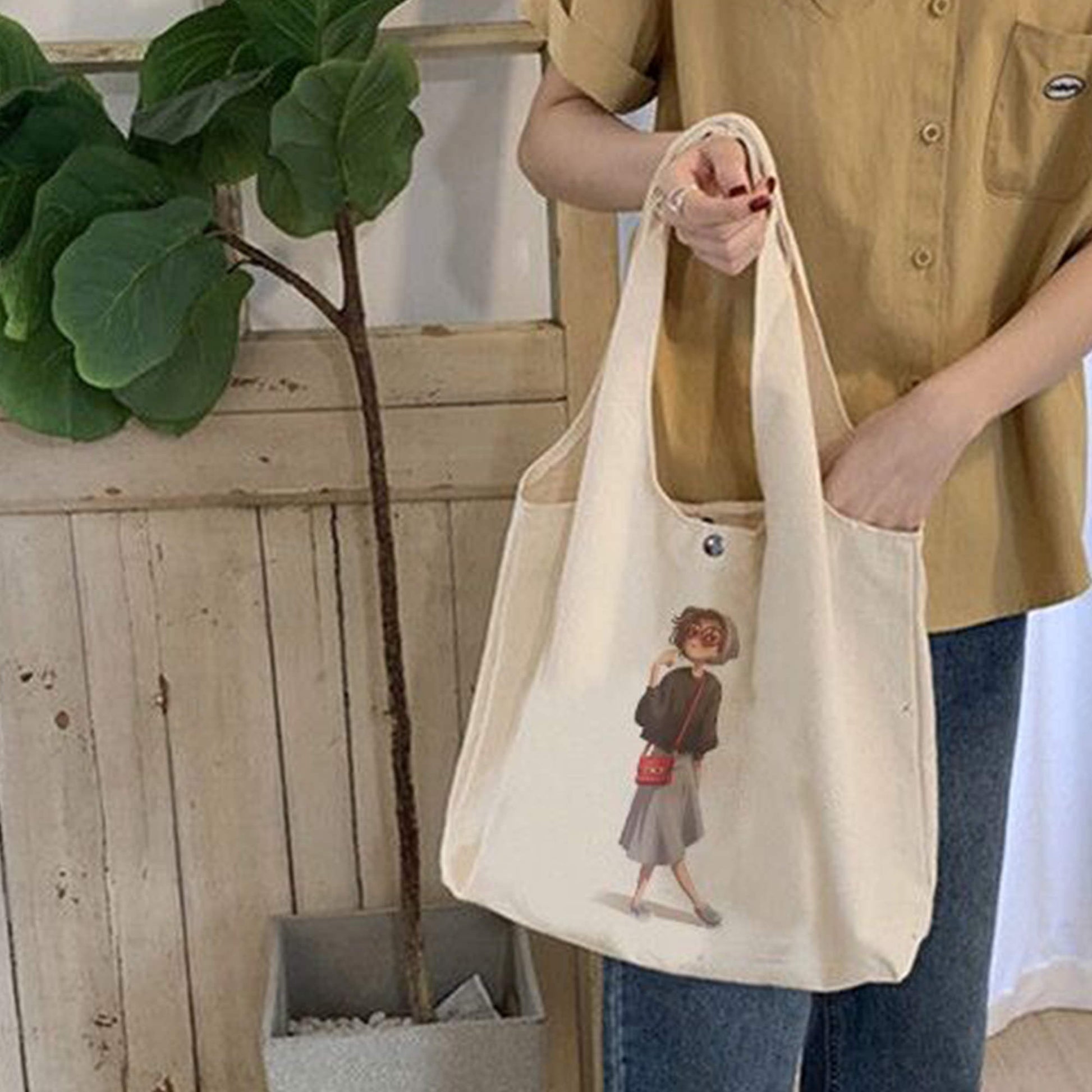 Woman holding a tote bag which is personalized with a picture of a girl on it.