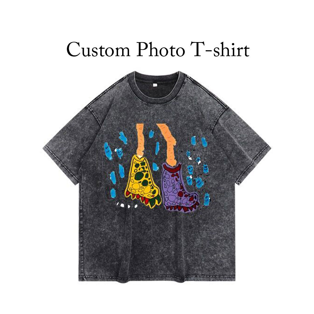 A photo of a t-shirt with a photo of two feet on it. The feet are brown and belong to a child.