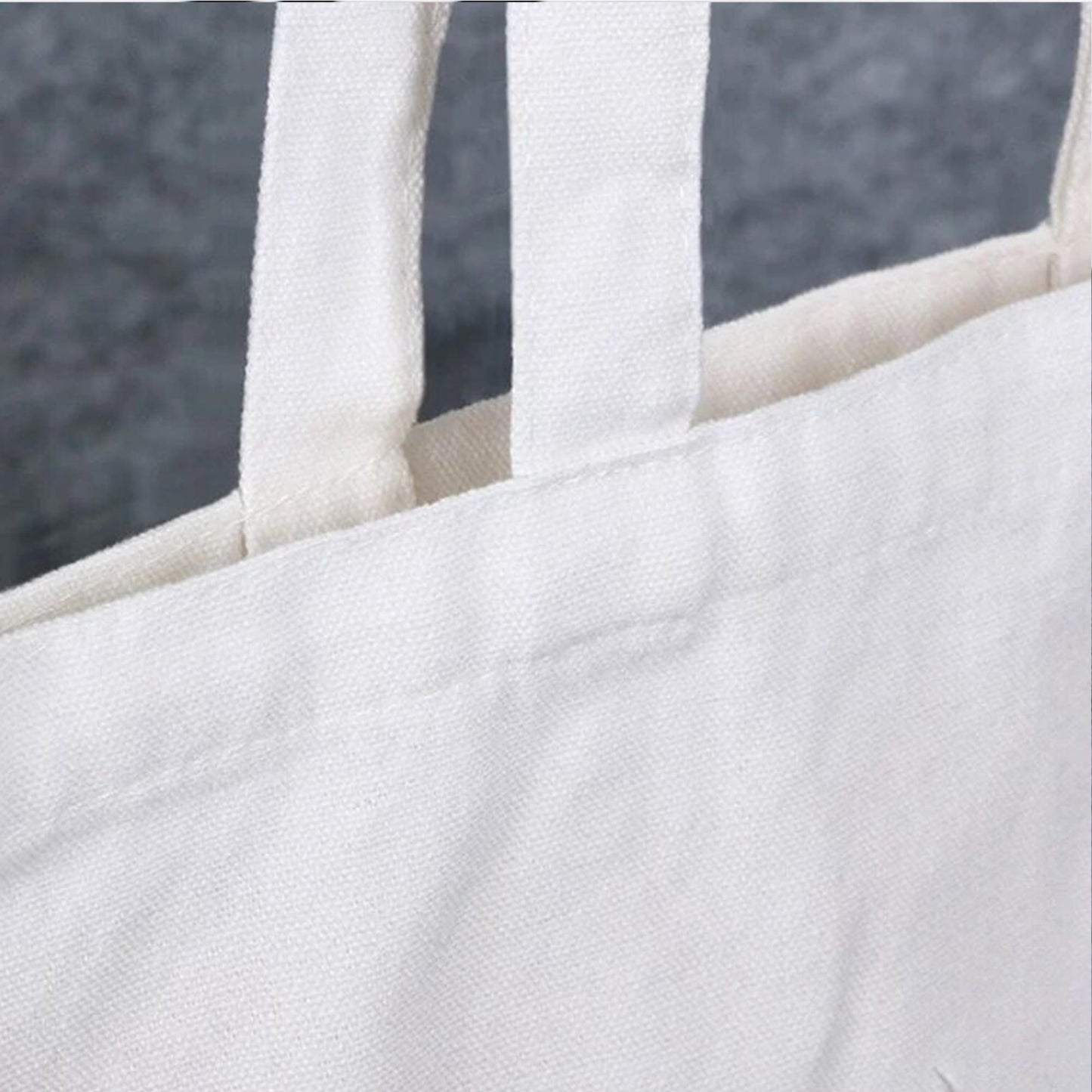 Close-up of the tote bag's sturdy handle, highlighting its durable construction and quality craftsmanship.