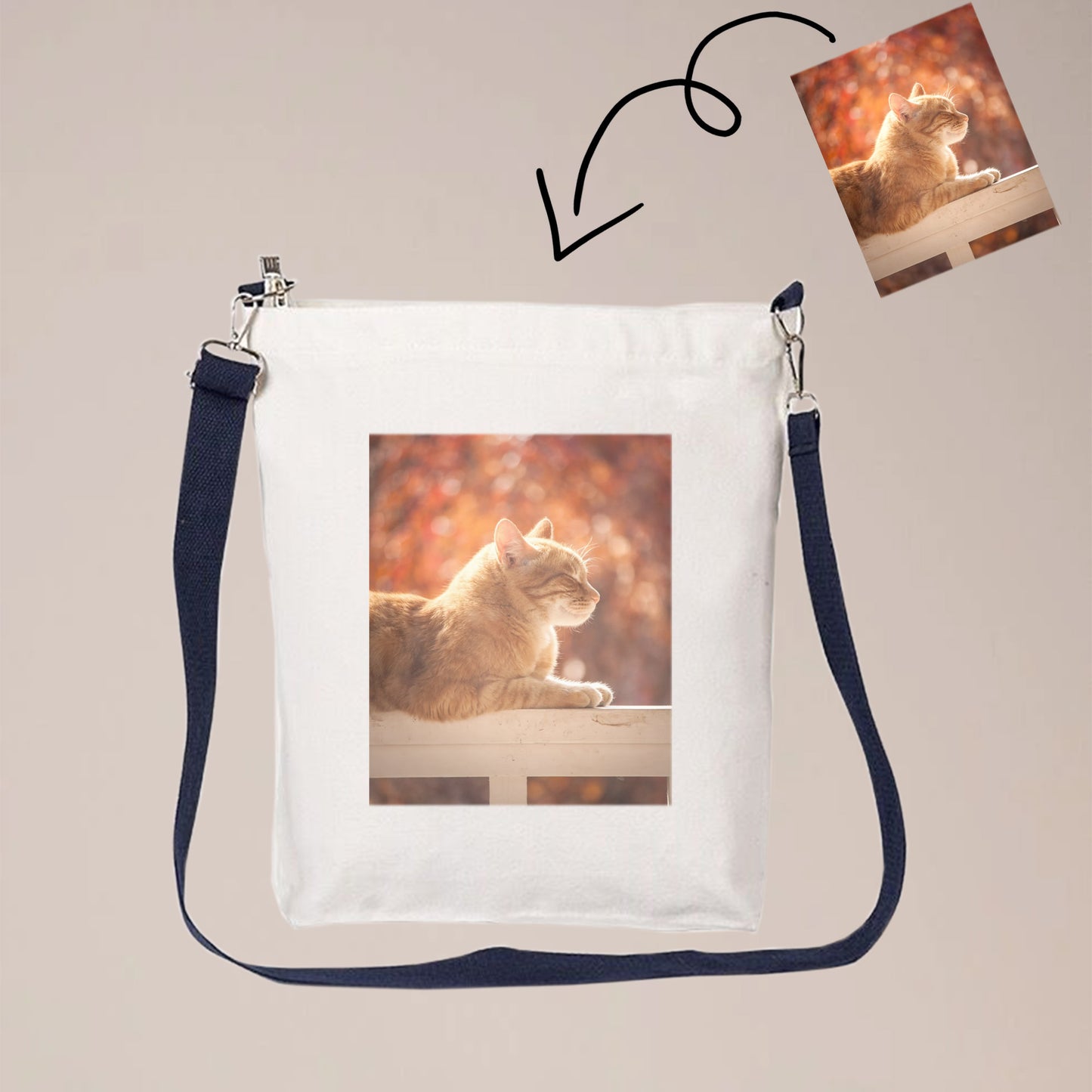 A beige canvas crossbody bag with one or two sided print with photos. The bag has a long strap that can be worn over the shoulder or across the body.