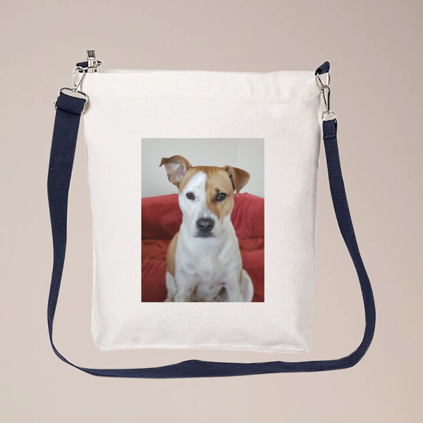 A photo of a dog is printed on a white canvas crossbody bag with a long, blue, and adjustable strap. People can personalize this crossbody bag with pet photos, initials, logos, text, etc.