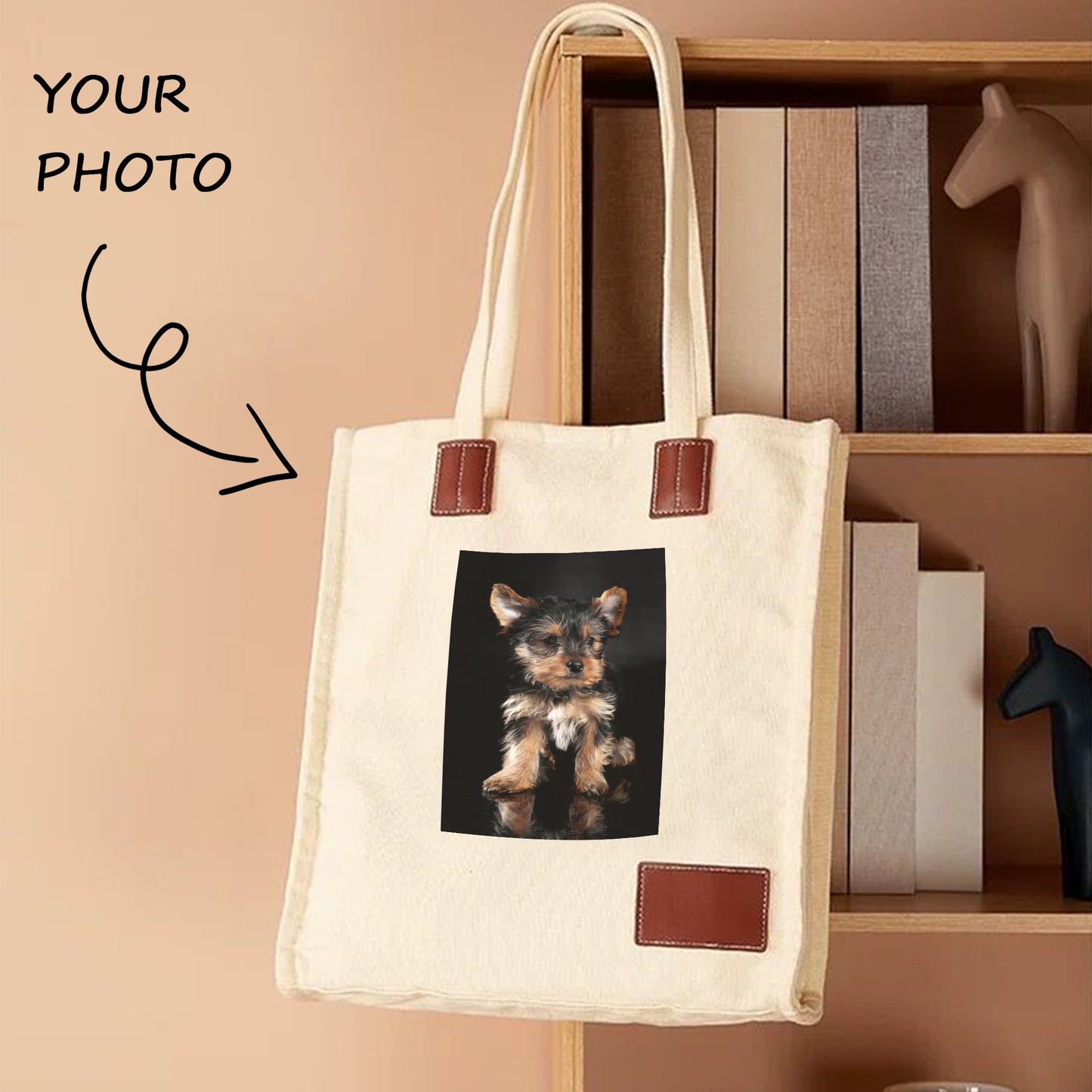 A white custom photo tote bag with an image of a dog on it hangs on the bookshelf. The tote bag is thick and in good shape.